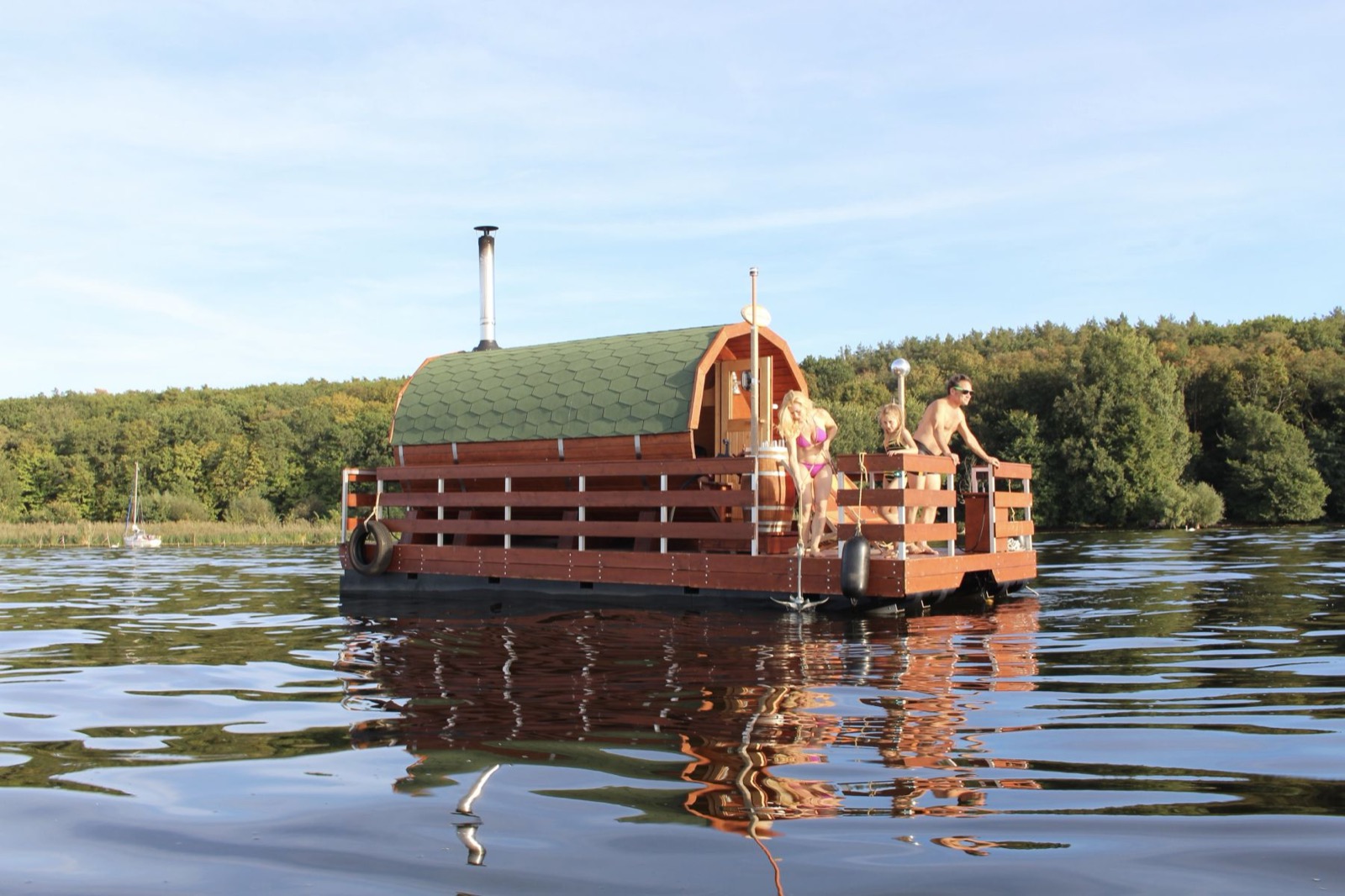 Gruppe auf dem Saunafloss vor bewaldetem Ufer